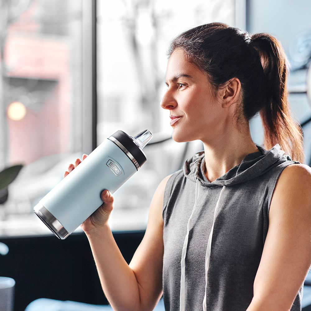 Person about to drink from the 18 ounce water bottle with straw lid.